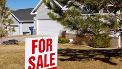 A 'For Sale' sign in front of a suburban home A 'For Sale' sign in front of a suburban home