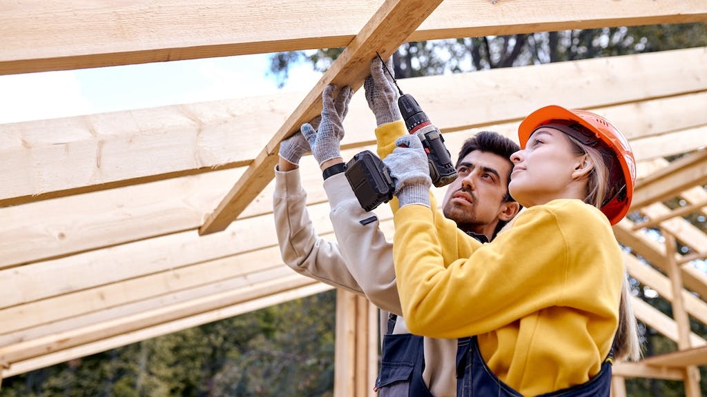 Female construction worker working alongside male coworker