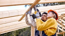 Female construction worker working alongside male coworker Female construction worker working alongside male coworker