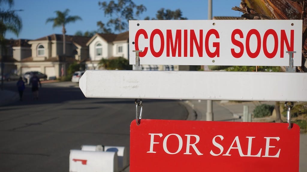 Sign in front of residential neighborhood that reads 'Coming Soon, For Sale'
