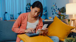 Woman goes over her budget on a calculator