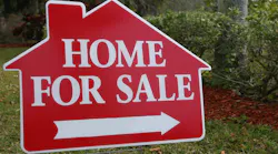 A red sign pointing to a home for sale