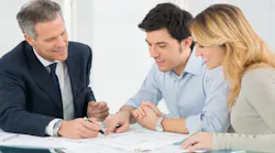 A real estate agent talks over options with a couple of homebuyers