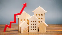 Wooden model homes with a red arrow pointing up, indicating price growth