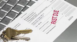A mortgage statement sits on top of a laptop with a red stamp that reads 'Past Due'