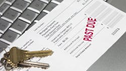 A mortgage statement sits on top of a laptop with a red stamp that reads 'Past Due' A mortgage statement sits on top of a laptop with a red stamp that reads 'Past Due'