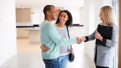 A couple shakes hands with a real estate agent while touring a home A couple shakes hands with a real estate agent while touring a home