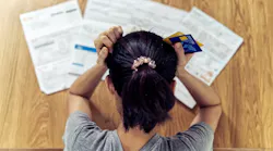 A stressed renter looks over credit card bills