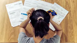 A stressed renter looks over credit card bills
