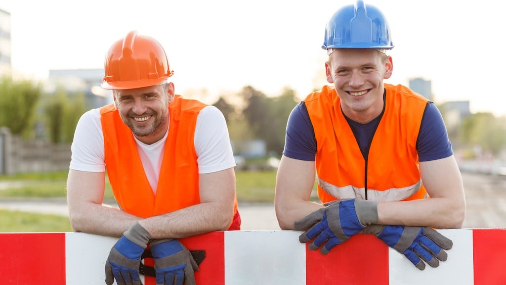 Two construction workers smiling for photo