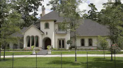 Exterior of gated luxury home surrounded by trees