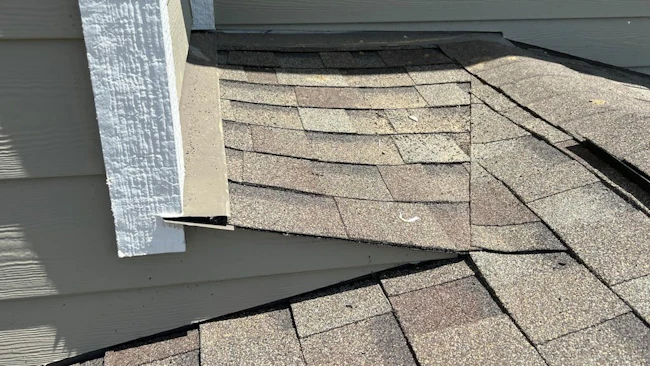 A properly formed cricket extends past the wall and directs water away from the roof-to-wall intersection