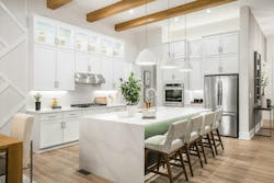 Soft gray fabric chairs at the kitchen island help add texture and warmth to the space. Soft gray fabric chairs at the kitchen island help add texture and warmth to the space.