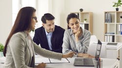 Real estate agent talking to a couple of homebuyers Real estate agent talking to a couple of homebuyers