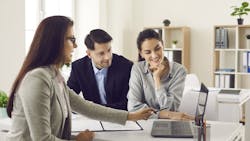 Real estate agent talking to a couple of homebuyers Real estate agent talking to a couple of homebuyers