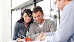 Homebuyers sign papers with a real estate agent Homebuyers sign papers with a real estate agent