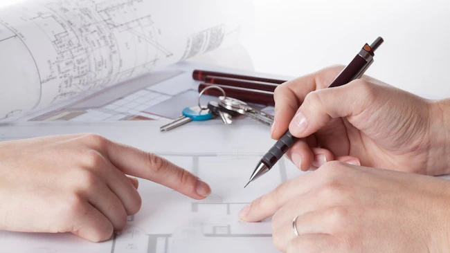 An architect works on house plan with a client