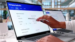 Woman fills out mortgage loan application on a laptop Woman fills out mortgage loan application on a laptop