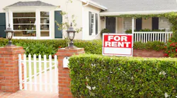 'For Rent' sign in front of a single-family home