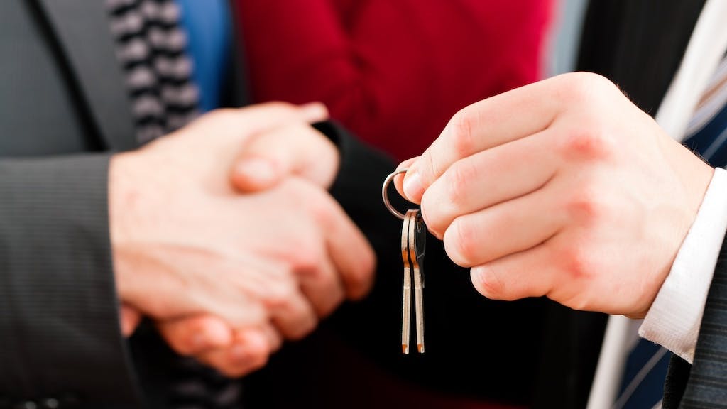 Real estate agent shakes hands with a homebuyer