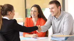 Homebuyers shaking hands with real estate agent