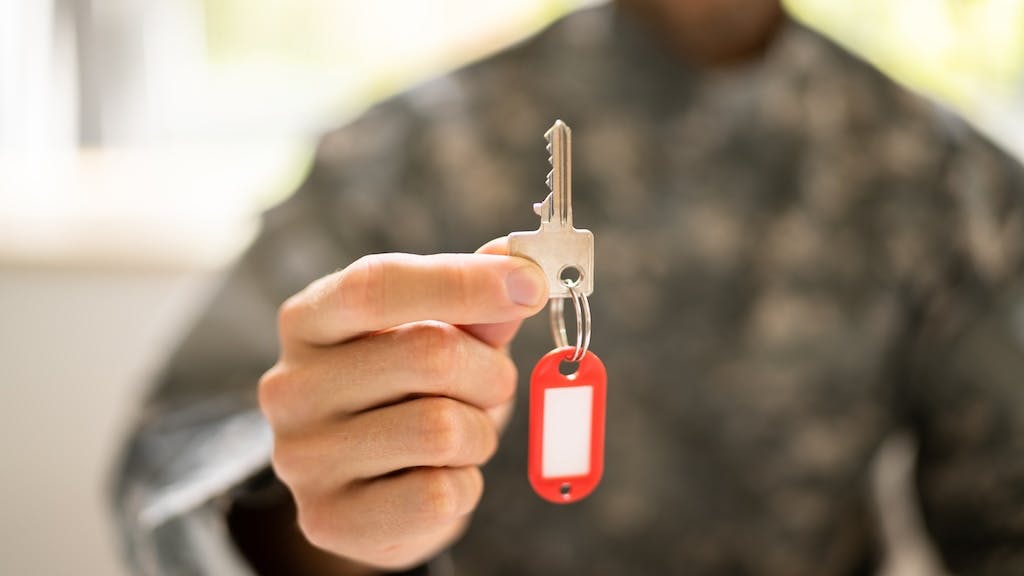 Veteran holding up a key to their new home
