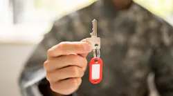 Veteran holding up a key to their new home