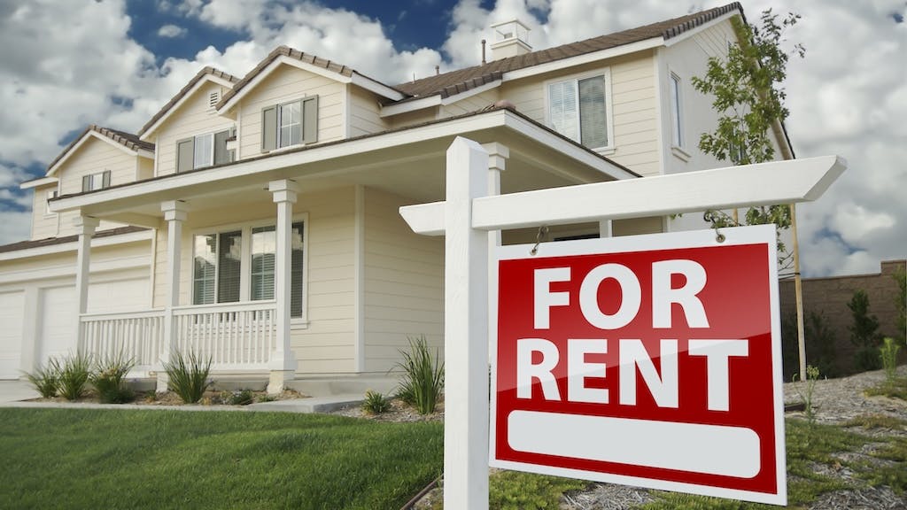 Home with a 'For Rent' sign in the front yard