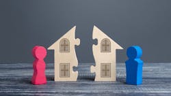 A model home split in half with a red and blue figurine on either side, representing the political divide in housing A model home split in half with a red and blue figurine on either side, representing the political divide in housing