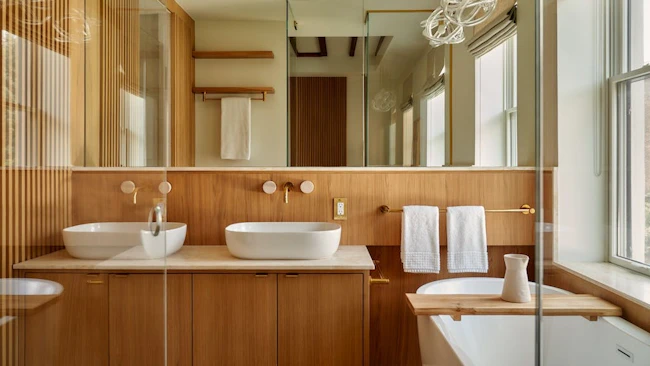 Bathroom showcasing flat-panel cabinets and wall-mounted faucets