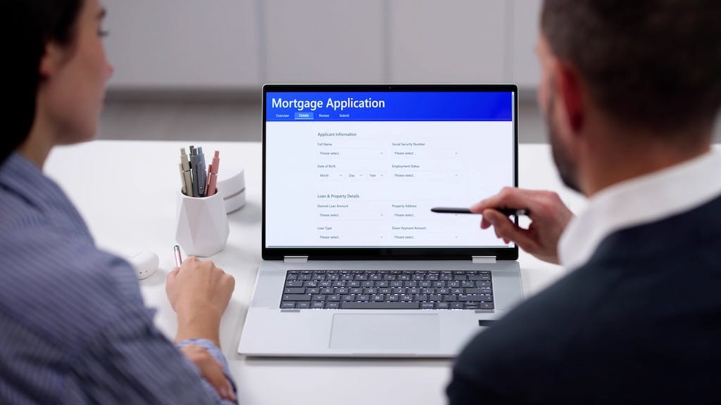 Homebuyers fill out a mortgage application on a laptop