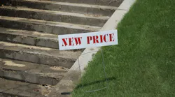 House with 'new price' sign in front yard