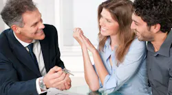 Real estate agent showing homebuyers the key to their new home