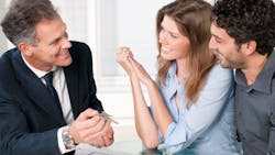 Real estate agent showing homebuyers the key to their new home Real estate agent showing homebuyers the key to their new home