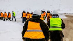 Line of construction workers walking in the snow Line of construction workers walking in the snow