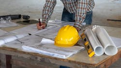 Home builder looking over plans at a jobsite Home builder looking over plans at a jobsite