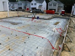 An excellent example of a setup for a conventional slab using welded wire mesh lifted on “chairs” for reinforcement over a well-sealed vapor barrier. An excellent example of a setup for a conventional slab using welded wire mesh lifted on “chairs” for reinforcement over a well-sealed vapor barrier.