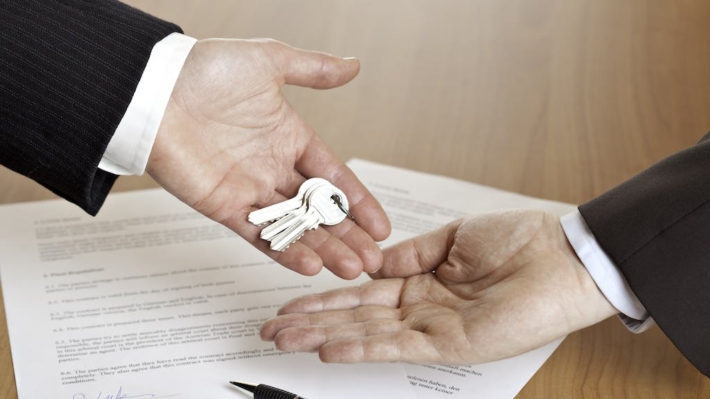 Real estate agent hands keys over to homebuyer