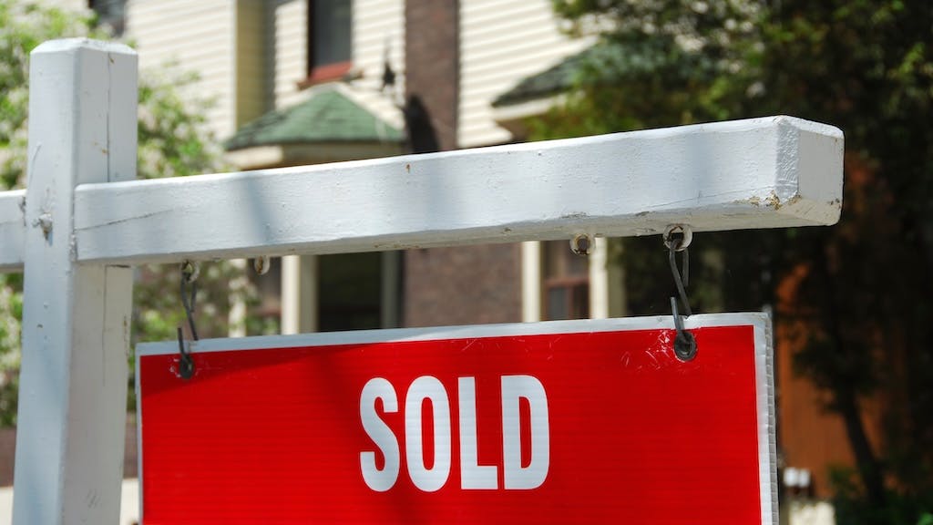 A 'sold' sign in front of a house
