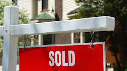 A 'sold' sign in front of a house A 'sold' sign in front of a house