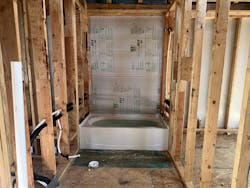 Rigid draftstopping installed and sealed behind tub and shower surround helps ensure insulation performs to its required rating, and also provides some measure of mositure mitigation. Rigid draftstopping installed and sealed behind tub and shower surround helps ensure insulation performs to its required rating, and also provides some measure of mositure mitigation.