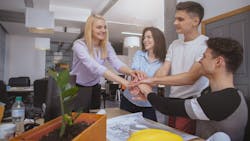 Residential construction team put their hands together, indicating they are on the same page Residential construction team put their hands together, indicating they are on the same page