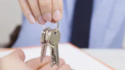 Real estate agent hands key to new homeowner