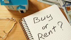 'Buy or Rent?' written on a notebook, next to a stack of cash and a model home 'Buy or Rent?' written on a notebook, next to a stack of cash and a model home