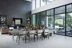 In the center of the great room, a dining table bridges the kitchen and the living room. The cantilevered table is bolted through the floor to a structural beam in the basement to create a unique and permanent focal point. Panels fronting the TV are speakers that separate to flank the screen. In the center of the great room, a dining table bridges the kitchen and the living room. The cantilevered table is bolted through the floor to a structural beam in the basement to create a unique and permanent focal point. Panels fronting the TV are speakers that separate to flank the screen.