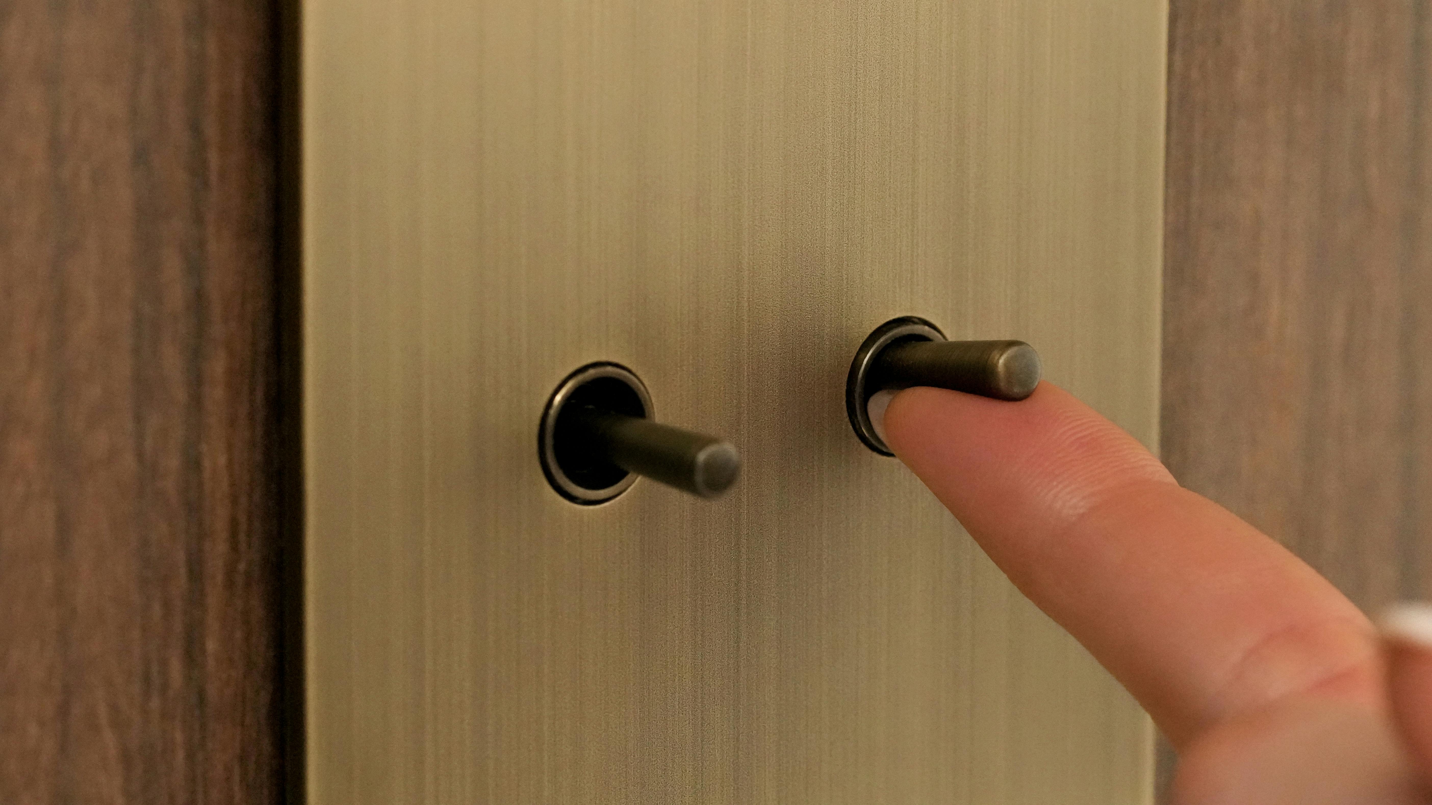 User turning off the Aviena Toggle Keypad by Lutron