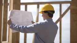 Home builder examining plans at a jobsite