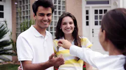 Homebuyers receive house key from a realtor