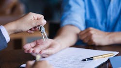 Homebuyer takes a pair of keys from real estate agent Homebuyer takes a pair of keys from real estate agent