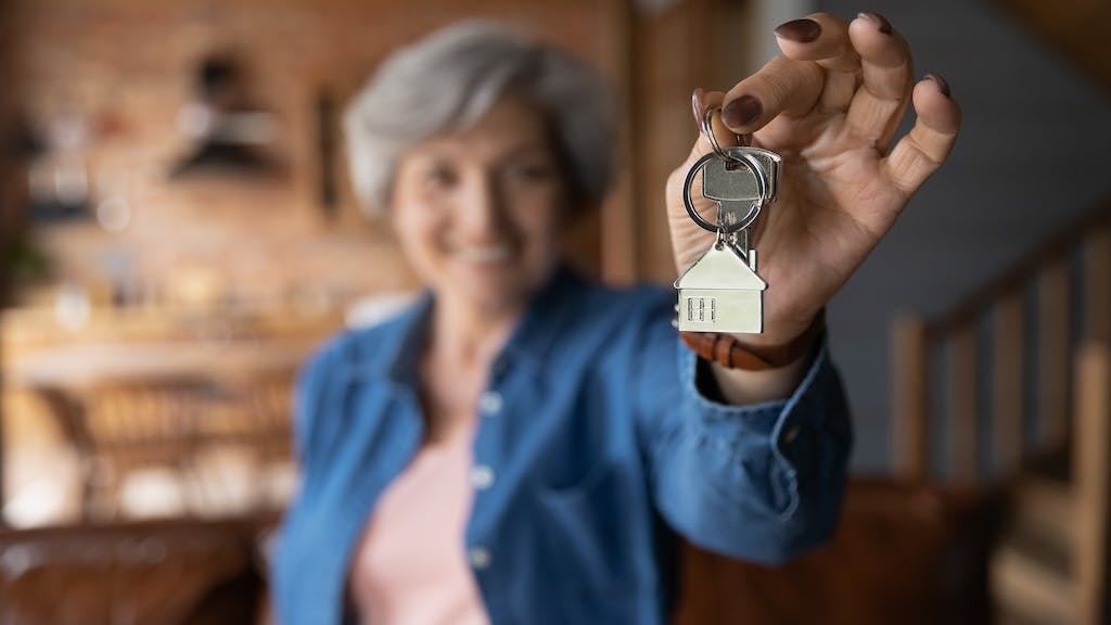 Older homeowner holding a set of keys